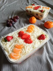 Plastic Container With Yummy Fruit Salad. Cheese, Strawbeery and Orange on Top. Selective Focus