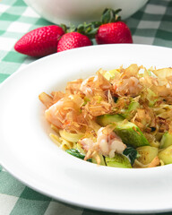 Spaghetti with shrimps, tuna shavings, and vegetables - zucchini, cucumbers, avocado.