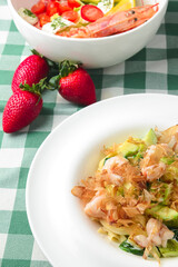 Spaghetti with shrimps, tuna shavings, and vegetables - zucchini, cucumbers, avocado.