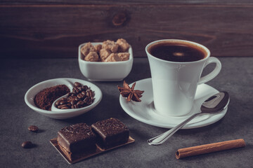 Cup of coffee and beans on table background. Set of coffee and sweets