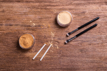 Mineral powder foundation with brushes on a wooden background. Eco-friendly and organic beauty products