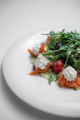 closeup of salad with salted salmon, cream cheese or arugula on white background