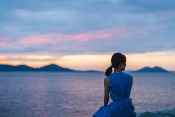 夕暮れの海にいる女性