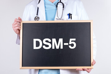 Doctor holding a blackboard with DSM-5 text