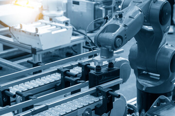 The hi-technology  material handling process by robotic system. The automatic pneumatic robotic arm picking the container box in production line.
