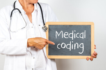 Doctor holding a blackboard with Medical coding text