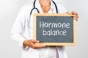 Doctor holding a blackboard with Hormone balance text