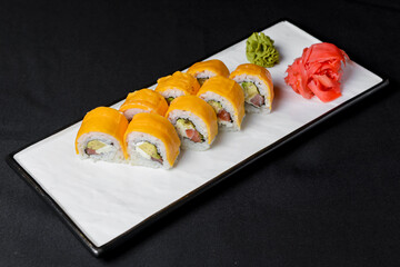 Sushi Rolls with processed cheese cheddar, american cheese, avocado, tuna and cream cheese inside on white slate