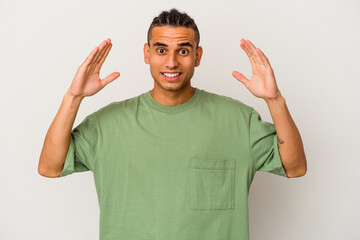 Fototapeta premium Young venezuelan man isolated on white background celebrating a victory or success, he is surprised and shocked.