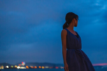夕暮れの海にいる女性