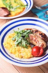 Risotto with pork sausages with cherry tomatoes and parsley on a plate. Italian cuisine concept
