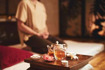 Man doing meditation during tea ceremony indoors - obrazy, fototapety, plakaty