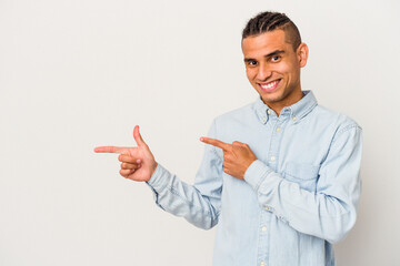 Young venezuelan man isolated on white background pointing with forefingers to a copy space, expressing excitement and desire.
