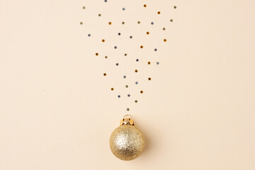 Christmas pastel beige minimal background with beige ball and confetti. Flat lay, copy space