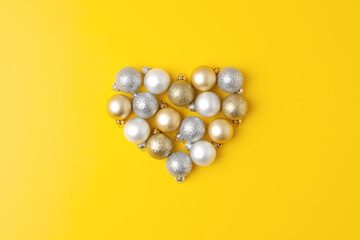Christmas minimal composition with grey and beige ball on yellow background. Flat lay, copy space