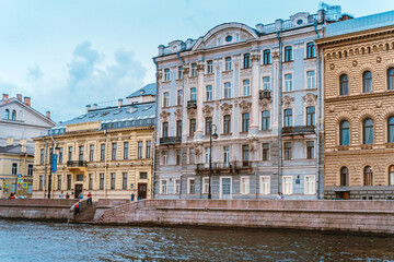 Naklejka premium Beautiful historical buildings on the embankment of St. Petersburg, photographed from a boat on the river. Saint Petersburg, Russia - 28 June 2021