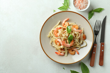 Concept of tasty eating with shrimp pasta on white textured table