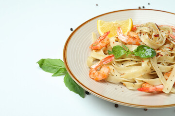 Plate of shrimp pasta on white background