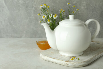 Concept of breakfast with chamomile tea on white textured table