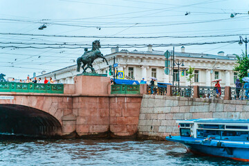 Anichkov Bridge on the embankment of St. Petersburg at sunset. Saint Petersburg, Russia - 28 June 2021