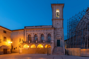 The Town Hall next to the facade of the Basilica of San Benedetto destroyed by the earthquake, Norcia, Italy, at the blue hour of twilight