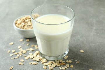 Glass of milk and cereals on gray textured background