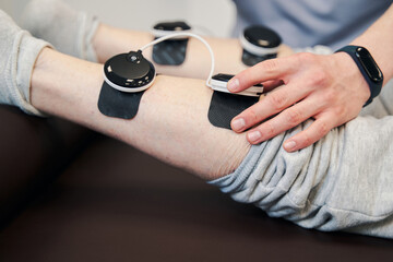 Obraz na płótnie Canvas Hand of manual therapist pressing button on stimulation module