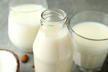Bottle and glasses with milk, coconut and almond, close up