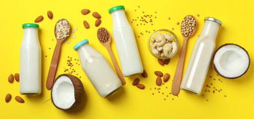 Fototapeta na wymiar Concept of vegan milk on yellow background, top view