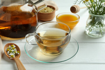 Concept of cooking chamomile tea on white wooden table