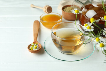 Concept of cooking chamomile tea on white wooden table