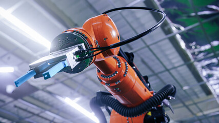 Industrial robot arm manipulating the assembly at the modern factory. Low angle shot. Realistic 3d...