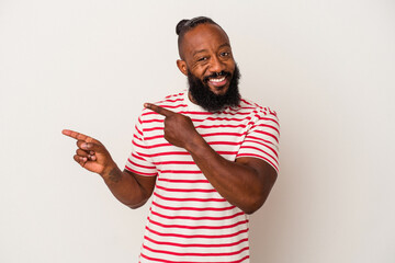 African american man with beard isolated on pink background excited pointing with forefingers away.