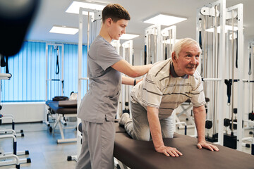 Obraz premium Old man standing on hands and knees doing gymnastics