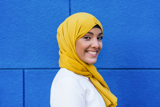 Stylish Muslim woman in yellow headscarf in city