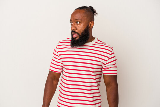 African american man with beard isolated on pink background being shocked because of something she has seen.
