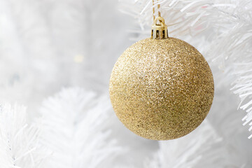 Gold color ball on white branch of chrismas tree background (Decoration for Christmas and New year festival)