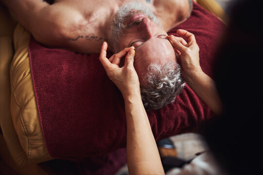 Grizzled guy relaxing during asian face massage