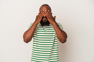 African american man with beard isolated on pink background afraid covering eyes with hands.