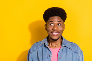 Obraz premium Photo of young happy afro american cheerful man look empty space dream isolated on yellow color background