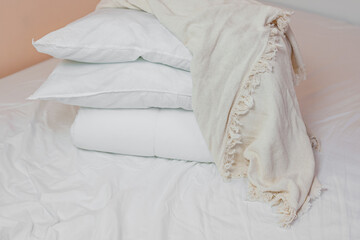Fototapeta na wymiar stack of white pillows and blankets lies on the bed on a white sheet on top, covered with a blanket