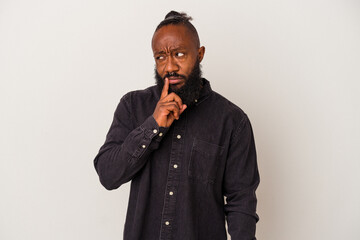 African american man with beard isolated on pink background looking sideways with doubtful and skeptical expression.