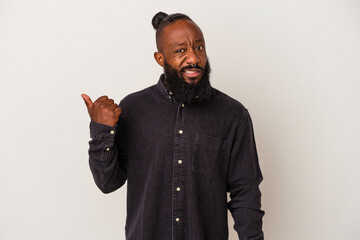 African american man with beard isolated on pink background shocked pointing with index fingers to a copy space.