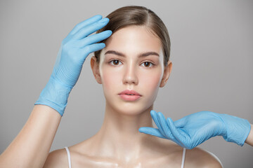 People, cosmetology, plastic surgery and beauty concept - surgeon or beautician hands touching...