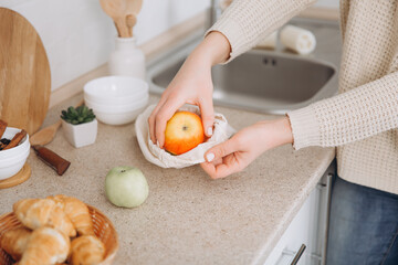 Woman's hand, holding a reusable grocery bag with vegetables.Zero waste