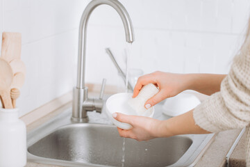 Woman washes dishes by eco brush.Zero waste