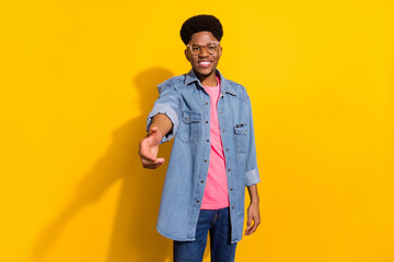 Photo of happy positive dark skin man good mood smile wear glasses handshake isolated on yellow color background