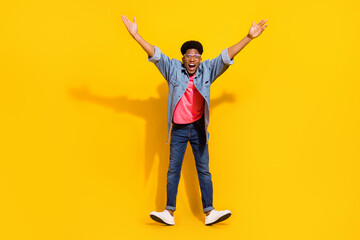 Fototapeta na wymiar Full size photo of amazed young dark skin man raise hands good mood shocked isolated on yellow color background