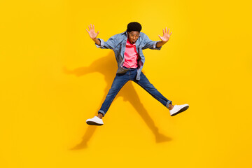 Fototapeta na wymiar Full length photo of happy dark skin young crazy man jump up active raise hands isolated on yellow color background
