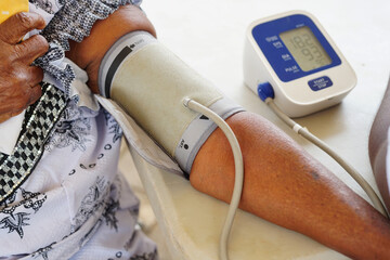 Close-up of a black people arm checking blood pressure with sphygmomanometer - concept on Africans...